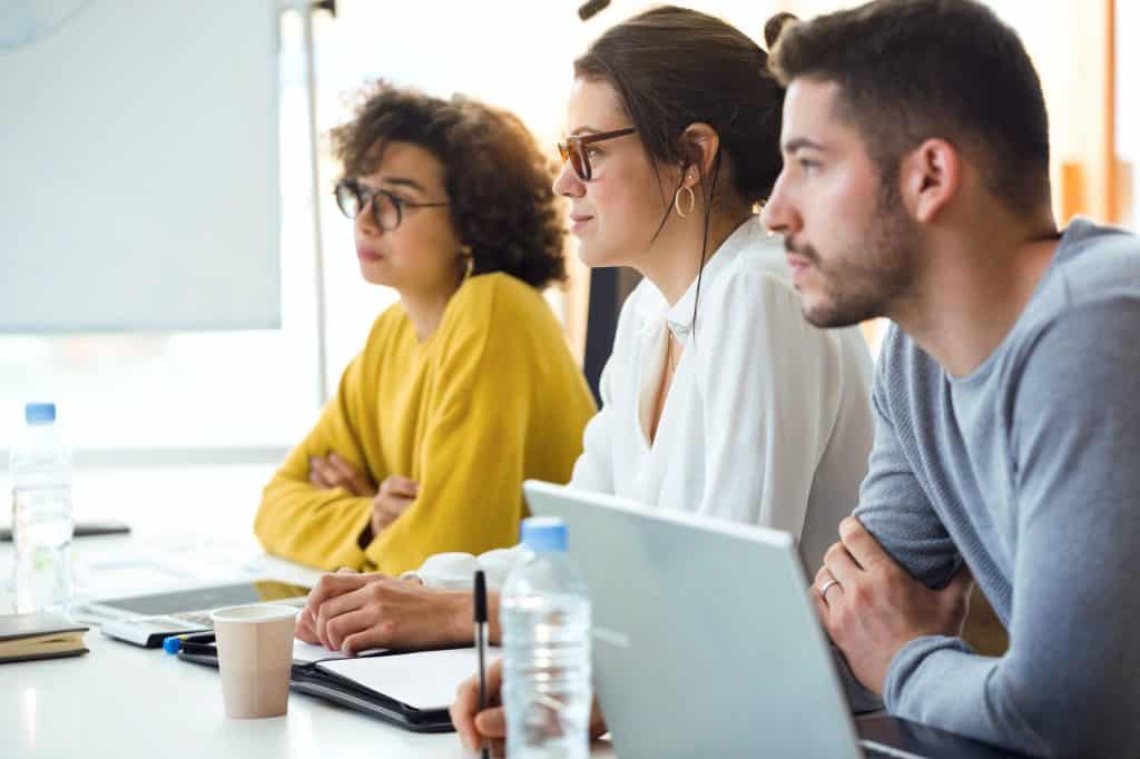 Young attractive businesspeople paying attention in conference o